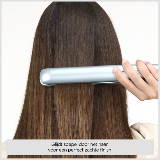 Hand die een lichtblauwe stijltang soepel door lang, steil bruin haar haalt voor een zachte finish.
