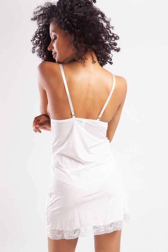 Model van achteren gezien in witte slipdress met kanten zoom. Schouderbandjes met verstelbare gesp.