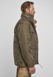 Man in olijfgroene winterjas, van de zijkant gezien, met bontgevoerde kraag.