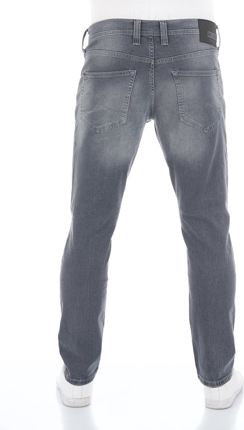 Man van achteren in een grijze Mustang jeans met zwarte logo-patch op de tailleband.