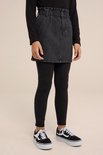 Meisje in een grijze denim rok met hoge taille, riem en zwarte legging.