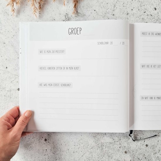 Open invulboek met vragen over de klas: 'Wie is mijn juf/meester?', 'Hoeveel kinderen zitten er in mijn klas?', 'Hoe was mijn eerste schooldag?'.