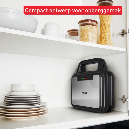 Zwart Tefal wafelijzer staat rechtop in een keukenkastje. Compact opbergontwerp.