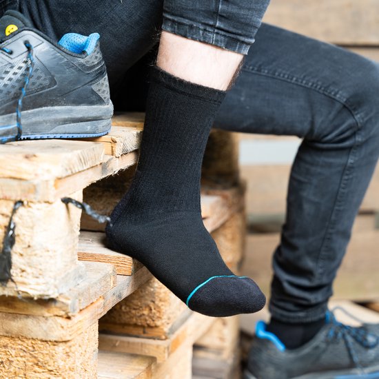 Man met zwarte werksokken met blauwe accenten en werkschoenen