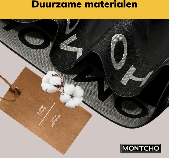 Zwarte stof van een boxershort met herhalende letters 'MONTCHO' op de grijze tailleband. Een kaartje met 'ORGANIC COTTON' en twee katoenbollen.