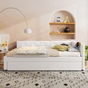 Witte slaapbank met uitschuifbaar bed, hexagonaal patroon op de rugleuning, met plaid en decoratieve kussens.