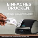 DYMO LabelWriter 5XL labelprinter, geprint adreslabel komt uit de printer, hand houdt labelrol vast.