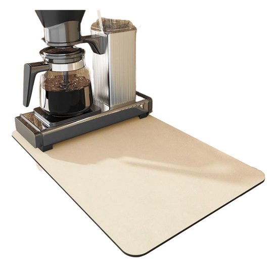 Koffiezetapparaat met glazen kan en RVS filterhouder op een beige mat.