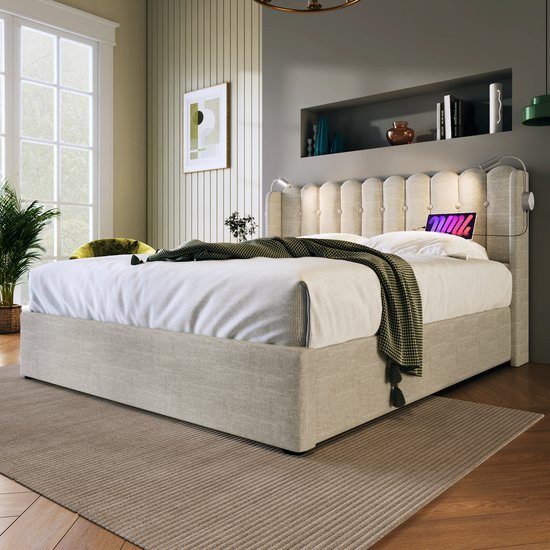 Gestoffeerd eenpersoonsbed in beige met een capitonné hoofdbord, twee leeslampjes en een matras met plaid.