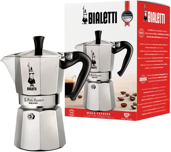 Cafetière Bialetti Moka Express 12 tasses en aluminium, avec poignée et bouton noirs. À côté d'un emballage rouge illustré.