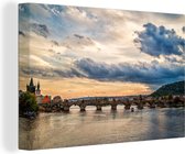 Canvas Schilderij Een wolkenlucht boven de Karelsbrug in Praag - 120x80 cm - Wanddecoratie