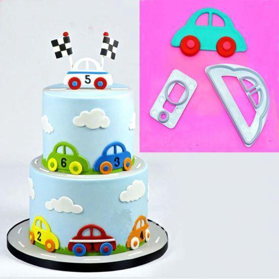 Taartdecoratie met een blauwe, tweelaagse taart met fondantauto's, wolken en racevlaggen. Links de uitsteekvormen.