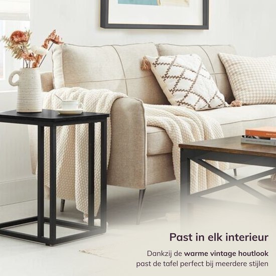 Zwart bijzettafeltje met een vintage houtlook, passend in elk interieur, naast een bank.