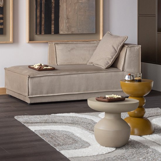 Beige chaise longue met een kussen en een bruine bijzettafel.