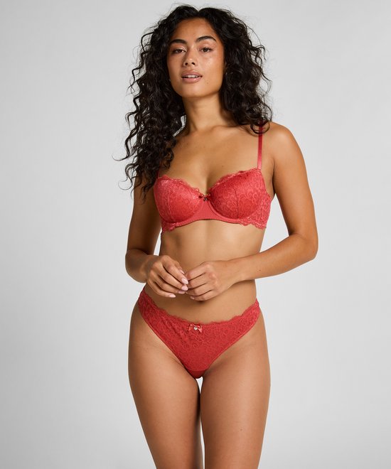 Model draagt rode kanten bh en bijpassende string, de bh heeft kanten details.