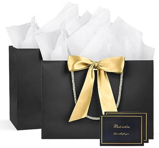 Un sac cadeau noir avec un nœud et des poignées dorés, rempli de papier de soie blanc. Deux cartes de vœux avec 'Best wishes' sont placées devant.
