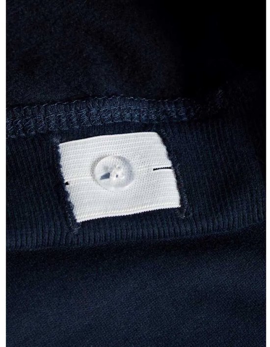 Detail van een verstelbare tailleband met knoopsluiting aan de binnenkant van een navy joggingbroek.