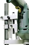 Close-up van een boorstandaard met groene boormachine, metalen geleidingsbuis.