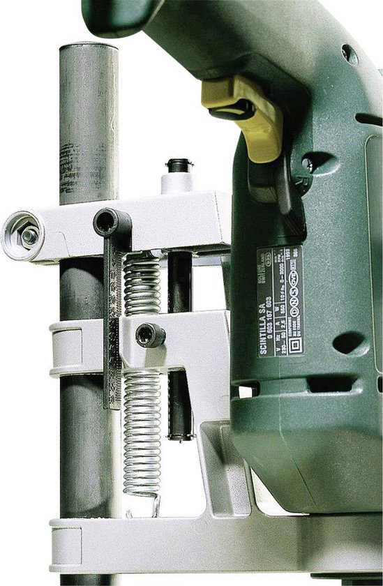Close-up van een boorstandaard met groene boormachine, metalen geleidingsbuis.