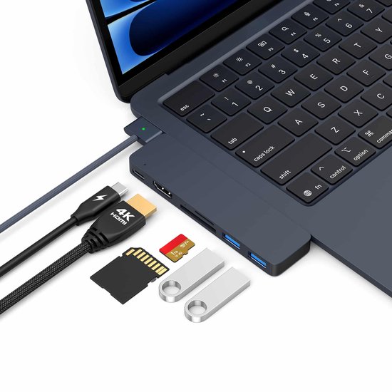 Een donkerblauwe USB-C dock is aangesloten op een laptop, met HDMI-kabel, SD-kaart, MicroSD-kaart en USB-sticks ernaast.