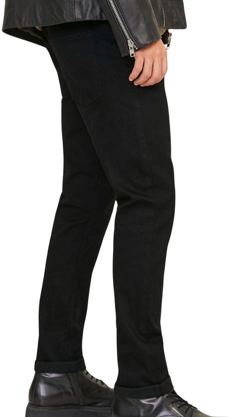 Zwarte jeans, van de zijkant gezien. Gedragen met een zwart leren jack en zwarte laarsjes.