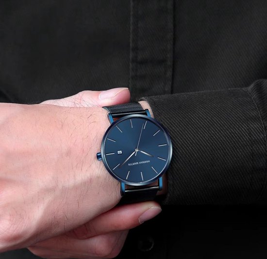Hannah Martin herenhorloge met blauwe wijzerplaat en mesh band om pols.