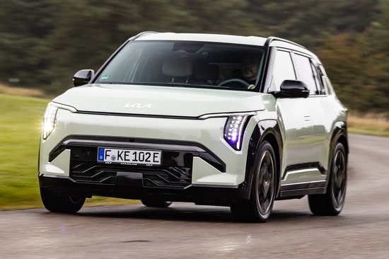 Lichtgroene Kia EV electric SUV rijdt op een weg.