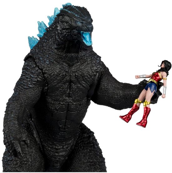 Godzilla actiefiguur die een Wonder Woman actiefiguur vasthoudt.