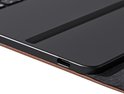 Zwarte tablet met USB-C poort, bevestigd aan een bruine hoes.