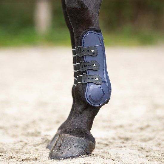 Donkerblauwe peesbeschermer met drie zwarte sluitingen, gedragen op het linker voorbeen van een paard.