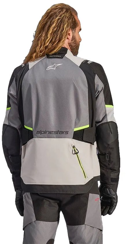 Motorjas met Alpinestars-logo op de achterkant, grijze en zwarte panelen, met fluo-gele accenten.