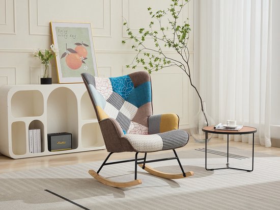 Fauteuil met patchwork design in diverse kleuren, in een woonkamer met witte kasten.