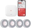 Wit X-Sense basisstation en vier witte rookmelders met rode ring, naast een smartphone met "Smoke Alarm Triggered" melding.