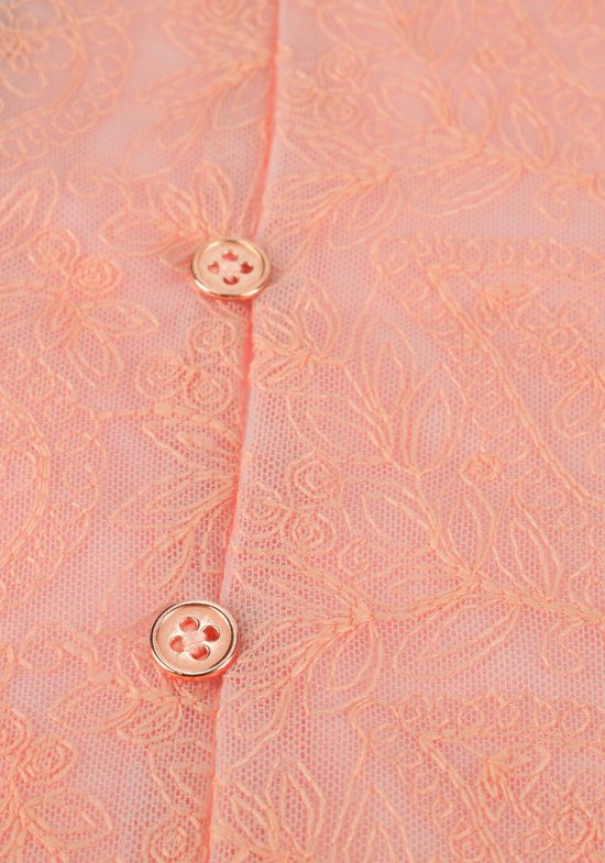 Close-up van twee koperkleurige knopen op een perzikkleurige kanten blouse.