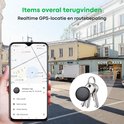 Hand houdt mobiele telefoon met GPS-locatie, naast een sleutelbos met zwarte Buzzy tracker, met gebouwen op de achtergrond.