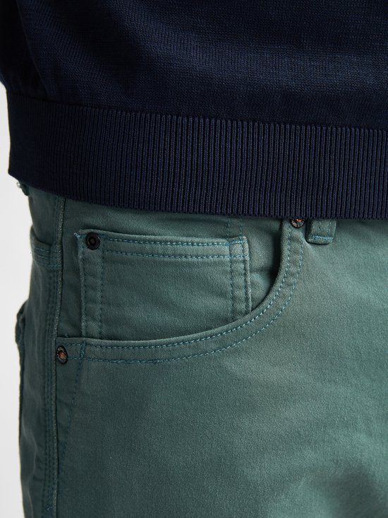 Detail van de zakken en het leren label van een groene slim fit stretch denim shorts.