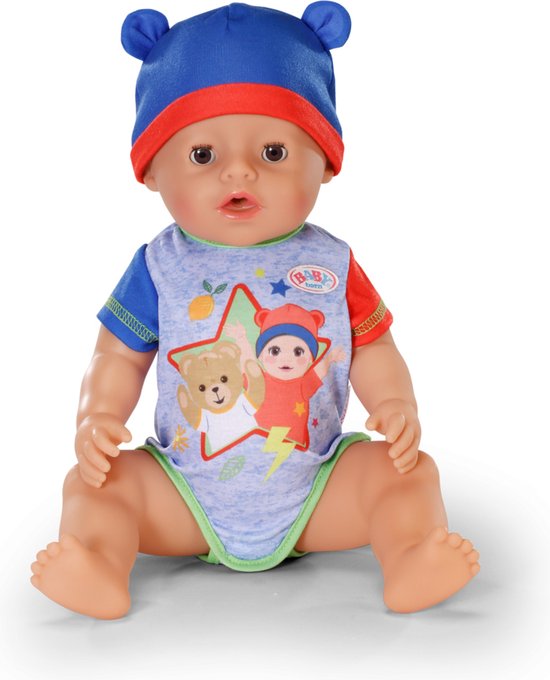 Jongen met blauwe muts en romper met beerprint. Zittend op witte achtergrond.