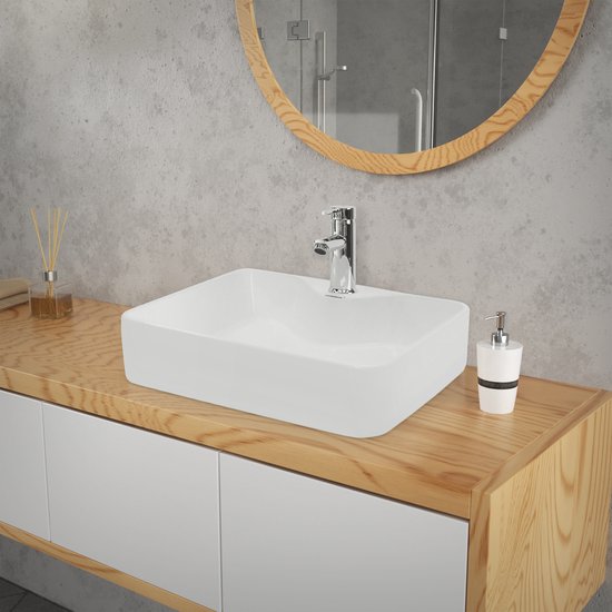 Lavabo rectangulaire en céramique blanche avec robinet chromé sur un meuble-lavabo en bois.