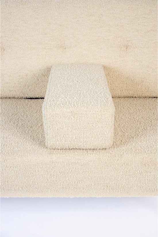 Close-up van een beige bouclé bank met een los kussen in het midden.