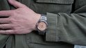 Citizen Eco-Drive horloge met perzikkleurige wijzerplaat, gedragen op een mannelijke pols.