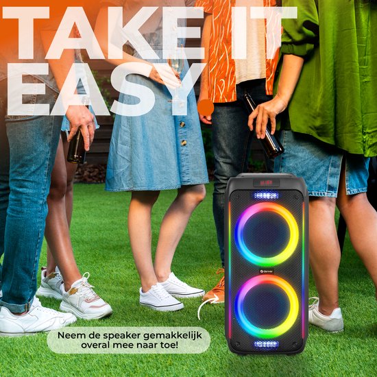 Denver speaker met dubbele luidsprekers en veelkleurige LED-ringen, op een grasveld bij vrienden.