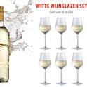 Set de 6 verres à vin blanc, à côté d'une bouteille de vin blanc avec des éclaboussures d'eau.