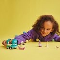 Kind met LEGO Friends bubbelthee kar, scooter en figuurtjes op gele achtergrond.