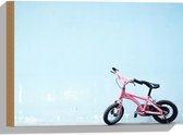 WallClassics - Hout - Roze Kinderfietsje tegen Blauwe Muur - 40x30 cm - 9 mm dik - Foto op Hout (Met Ophangsysteem)