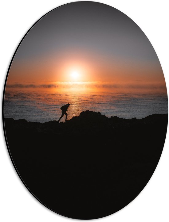 WallClassics - Dibond Ovaal - Man lopend over Berg aan de Zee met Zonsondergang - 30x40 cm Foto op Ovaal (Met Ophangsysteem)