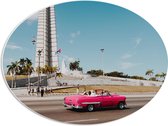 WallClassics - PVC Schuimplaat Ovaal - Roze Auto bij Gebouw in Cuba - 56x42 cm Foto op Ovaal (Met Ophangsysteem)