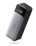 Zwarte en zilverkleurige powerbank met digitaal display en zichtbare USB-poorten aan de bovenkant.