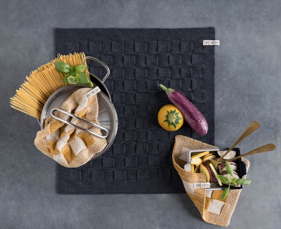 Keukenmat in antraciet met geweven patroon, met pan spaghetti, groenten, aubergine en handdoek in mosterdgeel-wit.
