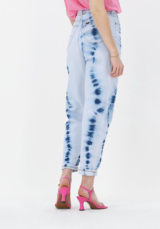 Lichtblauwe jeans met blauwe tie-dye print, gedragen door een model met roze sandalen.