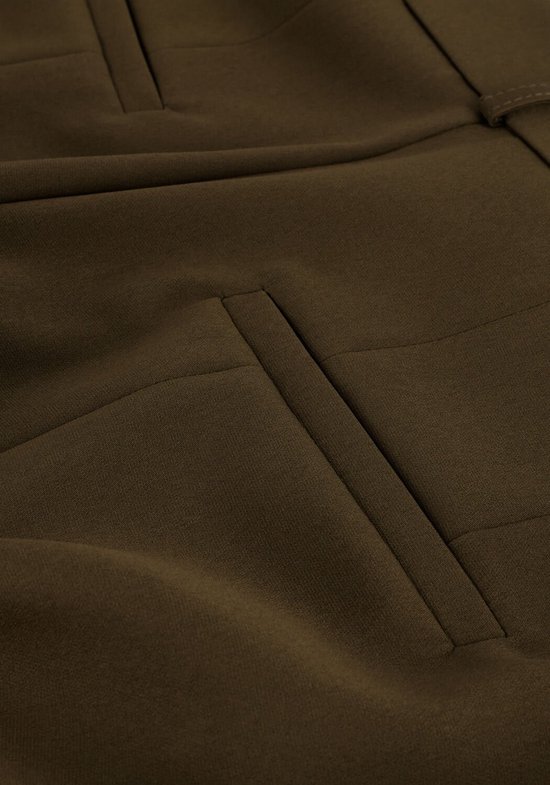 Detail van de zakken van een donkergroene pantalon.
